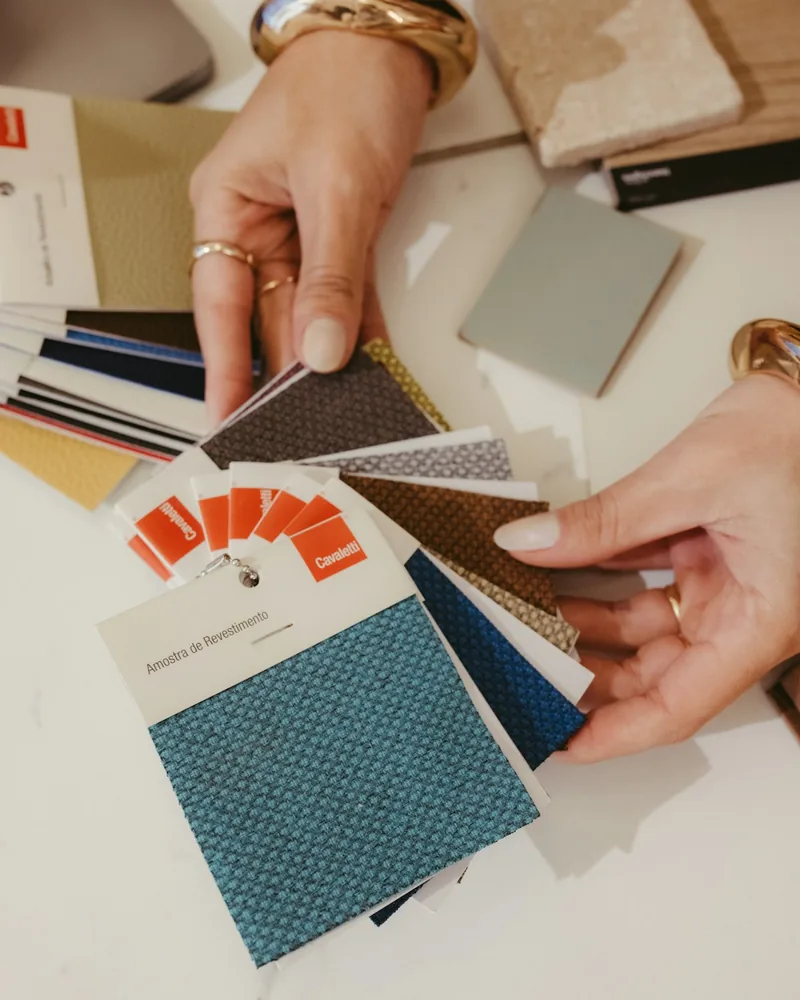 Rollos de tela estampada apilados en las estanterías de un taller de tapicería
